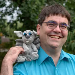 Potrait Andreas Unkelbach mit gehaekelten Gargoyle auf der Schulter